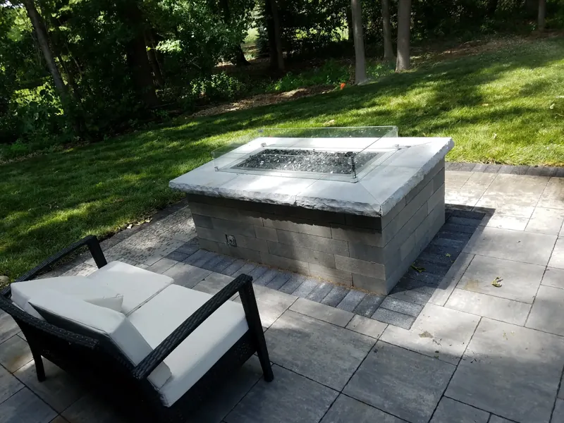Gas fire pit with natural-stone cap